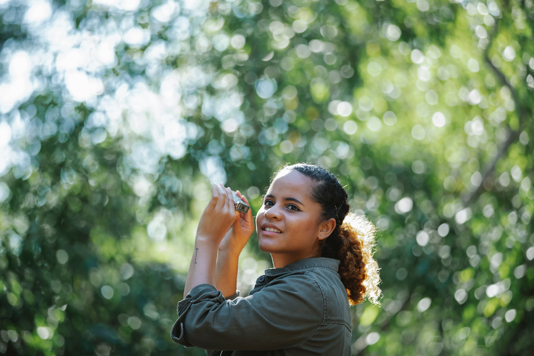 Glad ethnic woman with binocular looking away